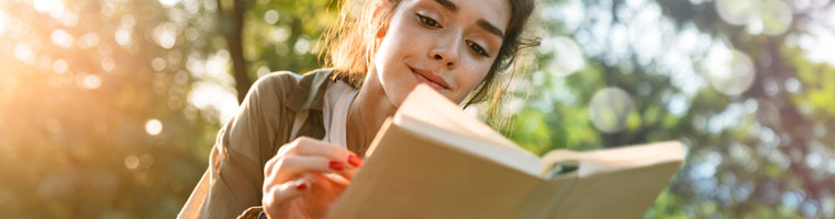Frau liest ein Buch in der Natur